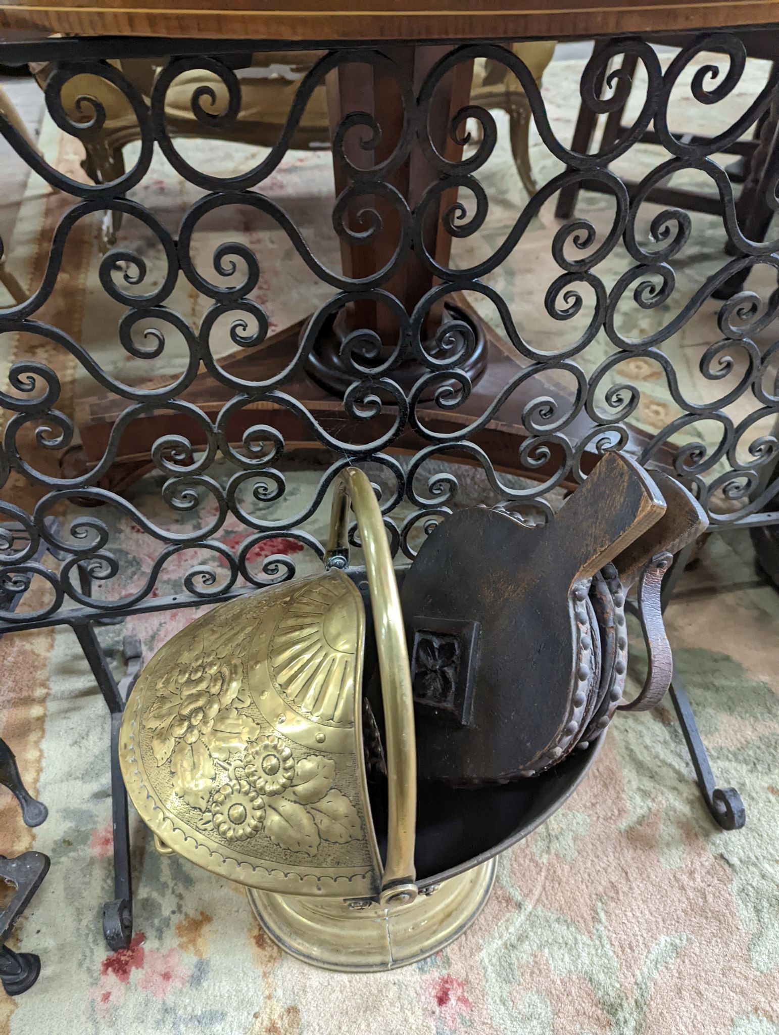 A wrought iron scroll work firescreen, width 95cm, a Dutch embossed brass scuttle, two trivets, coal bin and assorted metalware